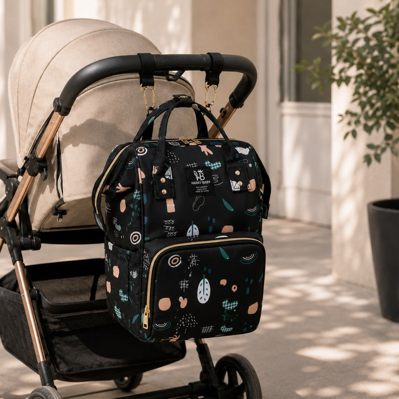 Sac à dos à langer bébé Harry Baby noir accroché aux poignées d'une poussette