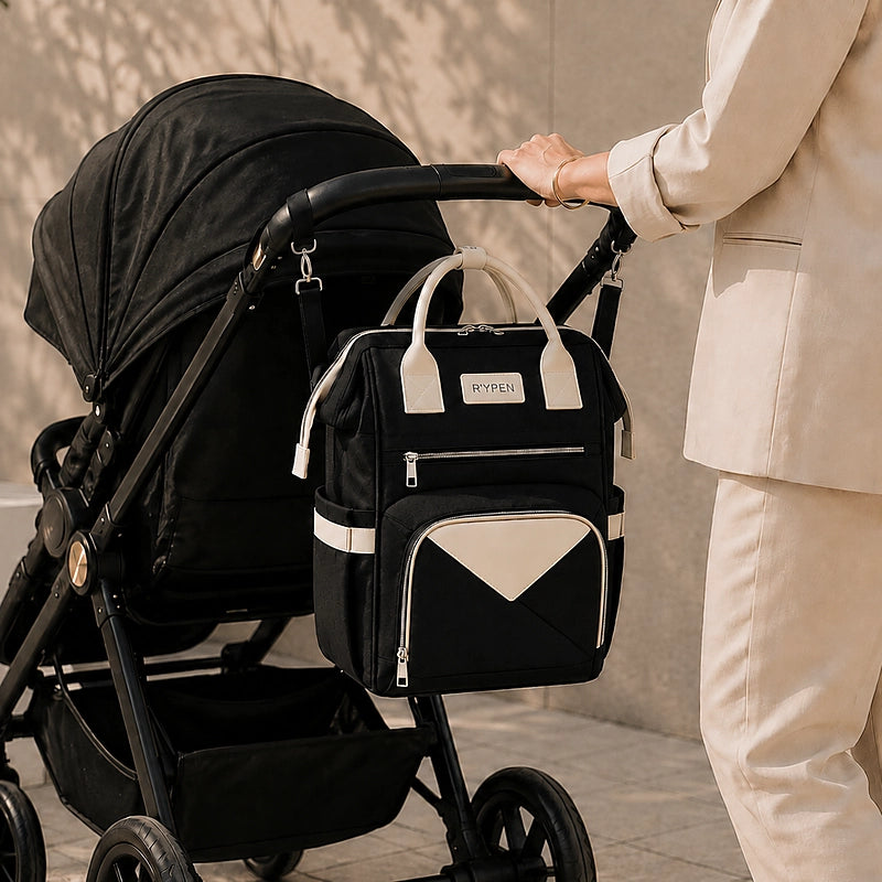 Sac à dos à langer noir suspendu à une poussette, tenu par une femme
