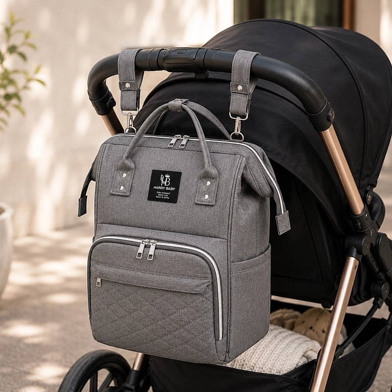 Sac à dos à langer multifonctions Daphné Harry Baby gris accroché à une poussette