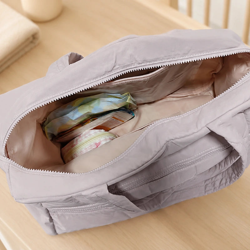 Intérieur du sac à langer épaule ouvert montrant le rangement pour couches et affaires bébé