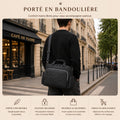Homme portant le sac à langer Promenade noir en bandoulière dans une rue de Paris, confort mains libres