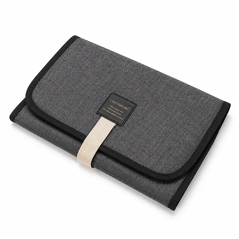 Tapis de change bébé nomade plié gris anthracite avec liseré noir et sangle de fermeture