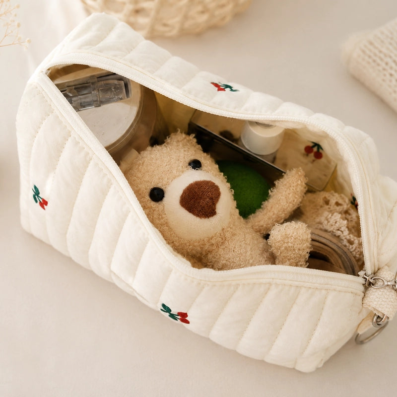 Intérieur de la trousse de toilette bébé motif cerises, doublure beige et broderies visibles