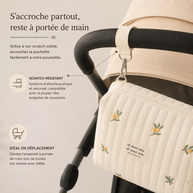 Trousse de toilette bébé motif citrons accrochée à la poignée d'une poussette grâce à son scratch résistant