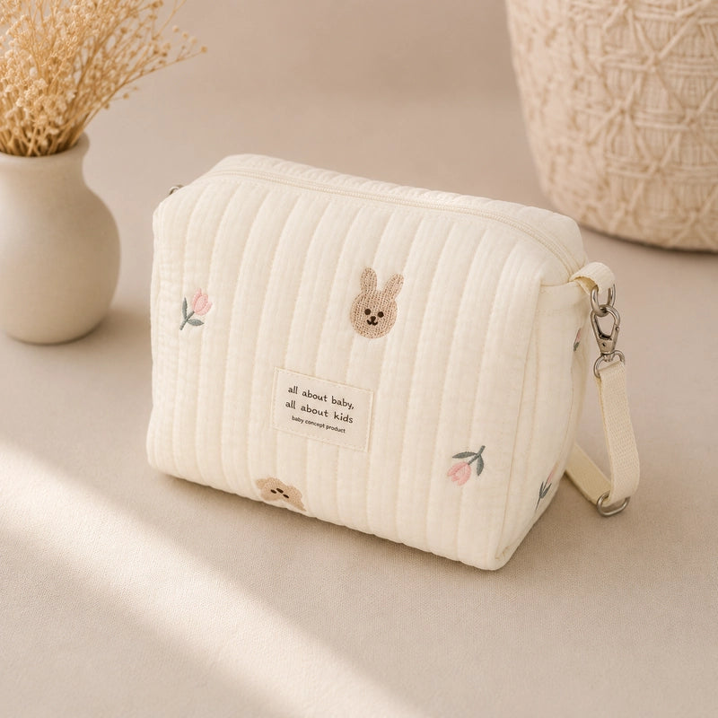 Trousse de toilette bébé matelassée écrue brodée lapin et fleurs roses, avec dragonne amovible